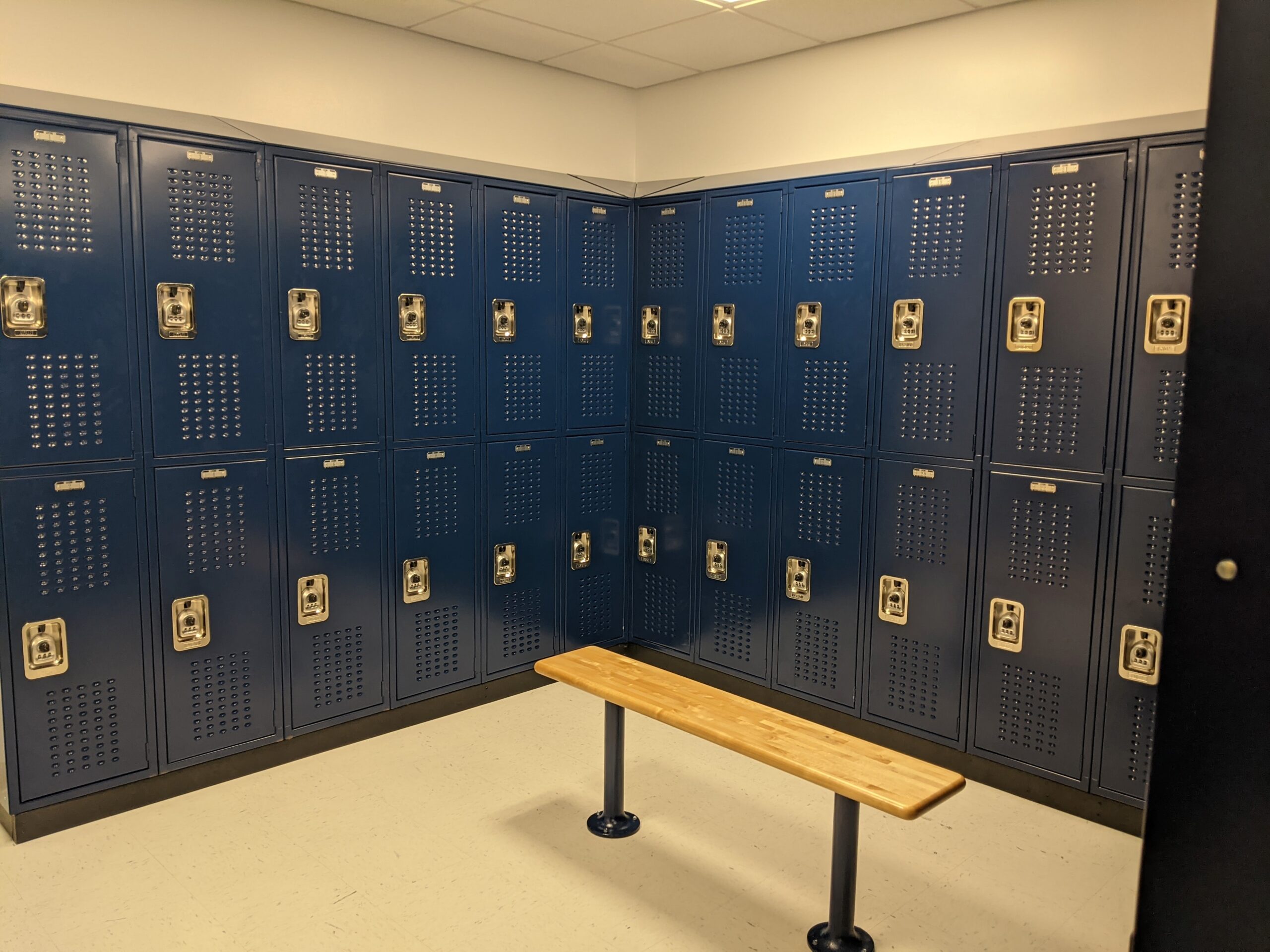 Blue vented two tier lockers at UNIS with a bench